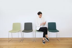 trendy girl in waiting room sending message with smartphone